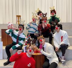 group of people dressed up as clowns sitting on steps with their noses covered in fake animals