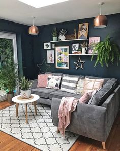 a living room filled with furniture and lots of plants on top of the windowsill