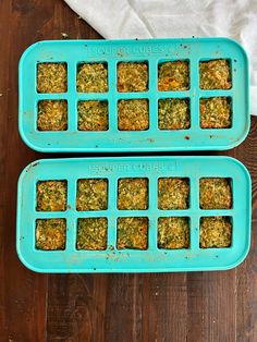 two blue trays filled with food sitting on top of a wooden table next to each other