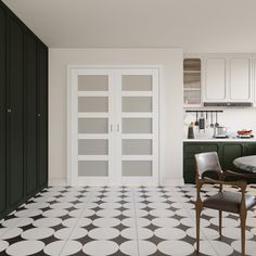 a kitchen with black and white tile flooring, cabinets and a dining room table