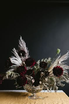 a vase filled with flowers on top of a wooden table