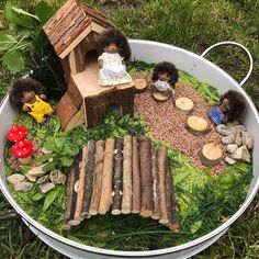 there is a birdhouse made out of wood logs and other things in the bowl