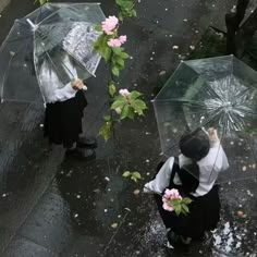 two people with umbrellas walking in the rain