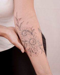 a woman's arm with a flower tattoo on the left side of her arm