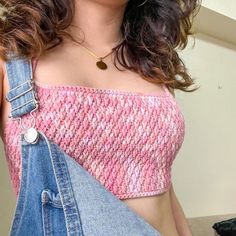 a woman wearing overalls and a pink top