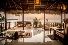 a woman laying on the floor in front of a jacuzzi tub at sunset