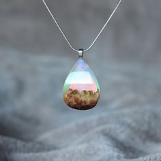 "A beautiful white opal necklace, handmade from simulated white opal, precious wood and resin. Makes for the perfect wood anniversary gift for her. The pendant is shaped and polished by hand. The high quality finish makes the wood silky smooth and the resin just like glass. Due to the nature of the materials, with its varying grains and colors, no two pieces will look exactly the same. Every piece is unique. If you would like to see photos of the exact piece you will be receiving, please leave a Resin Art Jewelry, Space Necklace, Woodland Jewelry, Wood Anniversary Gift, Blue Opal Necklace, Jewelry Nature, Gifts For Surfers, Unique Jewelry Gifts, Jewelry Resin