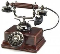 an old - fashioned phone is sitting on a wooden stand and has two dials