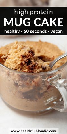 a close up of a dessert in a glass bowl with a spoon on the side