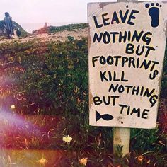 a sign in the grass that says leave nothing but footprints kill nothing, but time