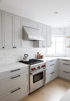 a kitchen with white cabinets and stainless steel appliances