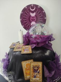 a cake decorated with tarot cards and a candle on the top, surrounded by other decorations