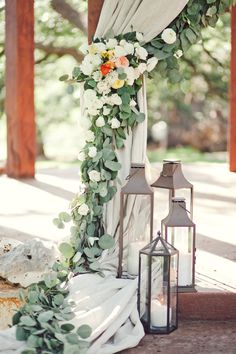 a wedding arch with flowers and candles