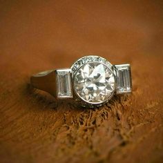 a diamond ring sitting on top of a piece of wood with diamonds in the middle