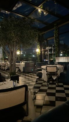 a restaurant with checkered flooring and tables set up for an event at night