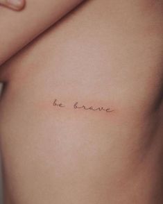 a woman's stomach with the word be brave written on it, in cursive font