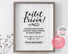 a framed poster with the words toilet rivia in black and white, next to a plant