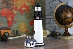 a small lighthouse on a wooden table next to a globe