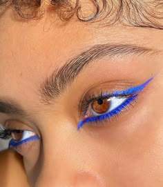 a close up of a person with blue eyeliners on their eyes and eyebrows