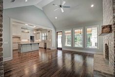 an empty living room with wood floors and windows