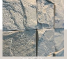 a close up view of a wall made out of white stone blocks with the words designer wall tiles written on it