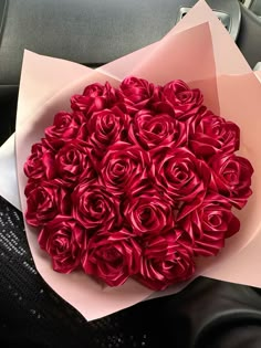 a bouquet of red roses sitting on top of a car seat