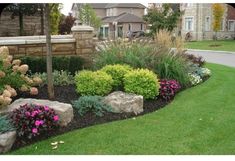 a garden with rocks and flowers in the grass