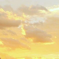 an airplane is flying in the sky at sunset or dawn with some clouds above it