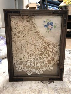 an old photo frame with crocheted doily on it