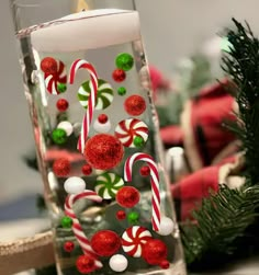 a glass filled with candy canes on top of a table