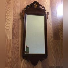 a mirror is hanging on the wall in a room with wood flooring and walls