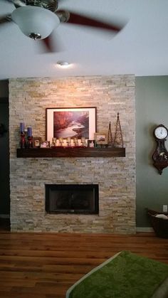 a living room with a stone fireplace and clock