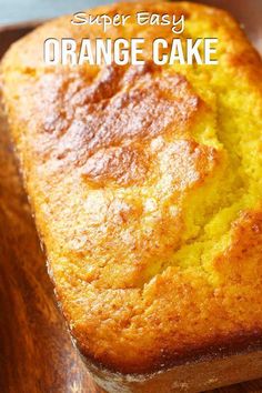 a loaf of orange cake sitting on top of a wooden cutting board with the title super easy orange cake