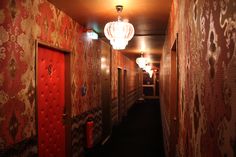 an empty hallway with red and gold wallpaper