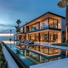 a large house with a swimming pool in front of it and palm trees on the other side