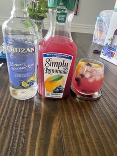 two bottles of lemonade, blueberry lemonade and raspberry lemonade on a wooden table