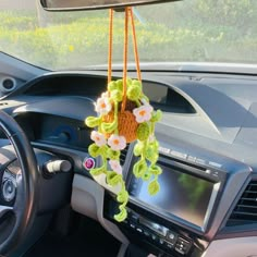 the interior of a car with flowers hanging from it's dash board and steering wheel