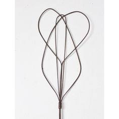 a heart shaped metal object hanging on a wall with two strings attached to it's sides