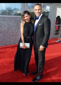 a man and woman standing on a red carpet