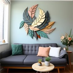 a living room filled with furniture and a large metal leaf wall decoration above the couch