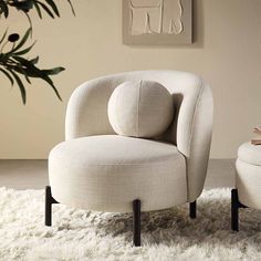 a white chair and ottoman sitting on top of a shaggy rug in a living room