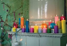 many different colored candles sitting on top of a mantle