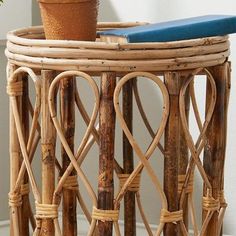 a potted plant sitting on top of a wicker table next to a wall