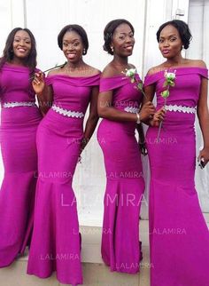 three women in purple dresses standing next to each other and one is holding a flower