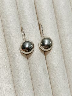 SILVER BALL DROP EARRING A modern ball drop earrings that are the perfect size. It reminds me of a gumdrop. It is a simple yet sophisticated piece for day and night. Lightweight and comfortable, these hollow balls give weighted look but ease on the ears and comes with rubber earring backs for extra protection. + Sterling Silver earrings + Listing is for 1 pair + 12mm Diameter + Please allow 5-7 business days to ship out. Silver Ball Earrings, Ball Drop Earrings, Minimalist Earring, Earring Silver, Ball Drop, Earring Gift, Sterling Silver Dangle Earrings, Drop Earring, Silver Earring