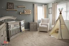 a baby's room with a teepee tent in the corner