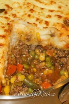 a close up of a pie with meat and vegetables in it on a plate next to a fork