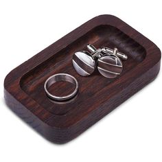 two silver rings are sitting on a wooden tray