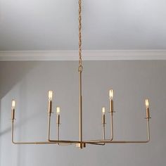 a chandelier hanging from the ceiling in a room with white walls and flooring