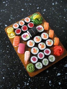 sushi on a wooden board with various vegetables and sauces in the middle,